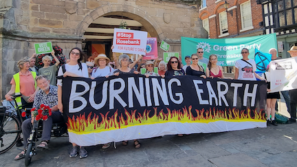 Protesters in Shrewsbury holding a large banner with the words "Burning Earth"
